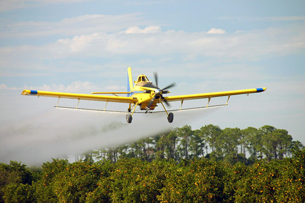 Air Tractor AT-802 aircraft performing aerial application over agricultural fields, showcasing its capabilities in crop dusting and pest control.