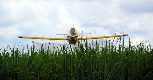 Air Tractor agricultural aircraft preparing for takeoff over a field, ideal for crop dusting and aerial application in farming.