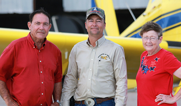 Bruton family stand in front of an Air Tractor aircraft, showcasing a strong connection to agricultural aviation. The image highlights the community and expertise surrounding the use of Air Tractor planes in farming operations.