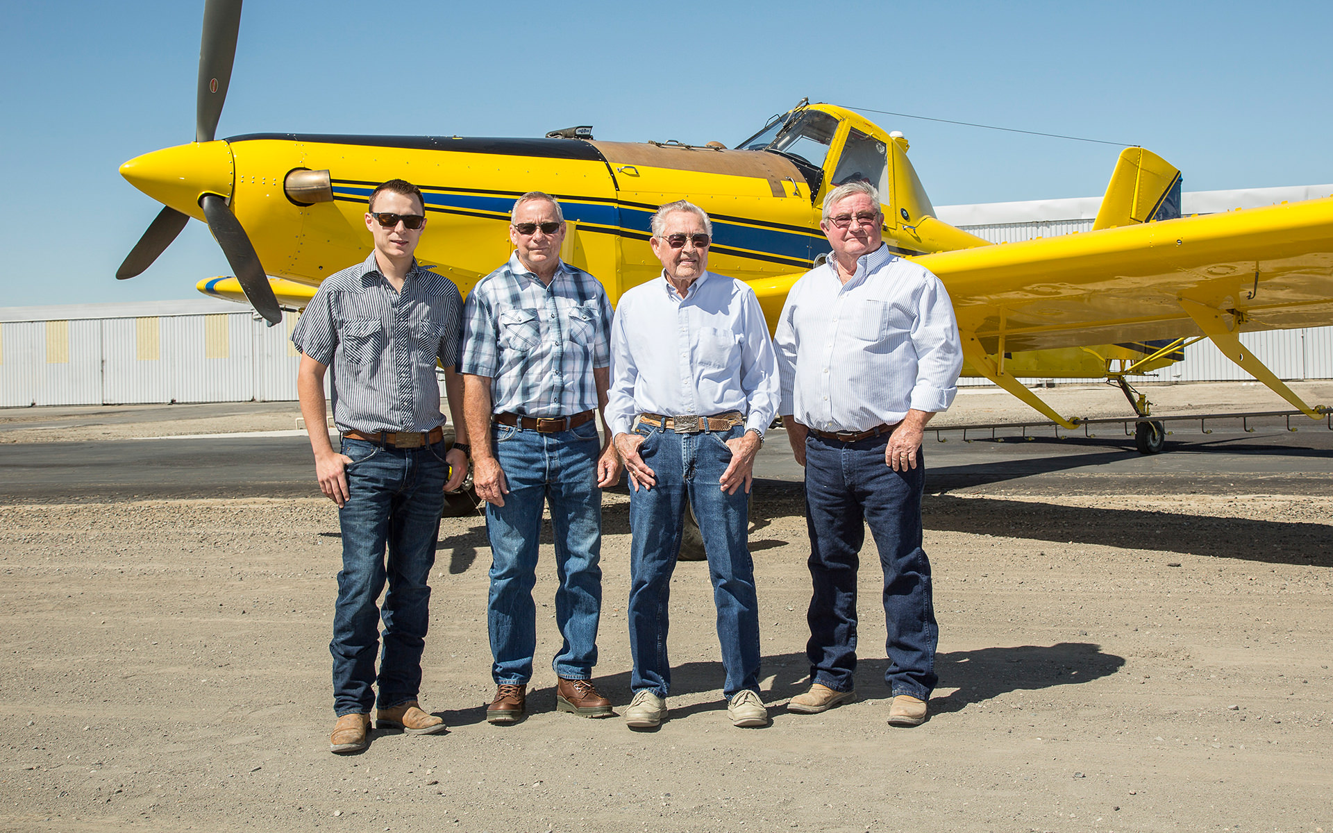 Grouleff men standing in front of an Air Tractor agricultural aircraft, showcasing the company's commitment to innovative aviation solutions for crop dusting and aerial application. The plane model is likely an Air Tractor AT-502B, known for its efficiency and reliability in agricultural operations.