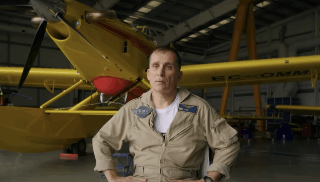 Titan pilot seated in front of an Air Tractor AT-802F in a hangar giving an interview about training, showcasing firefighting technology and operations.