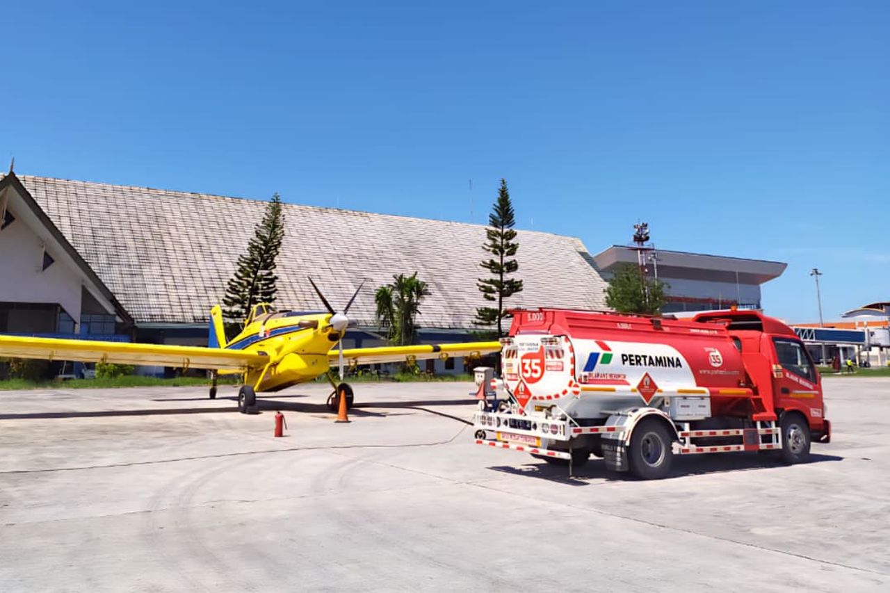 Air Tractor agricultural aircraft refueling at an airstrip, showcasing its robust design and versatility for crop dusting and aerial application. A fuel truck from Pertamina is visible in the foreground.