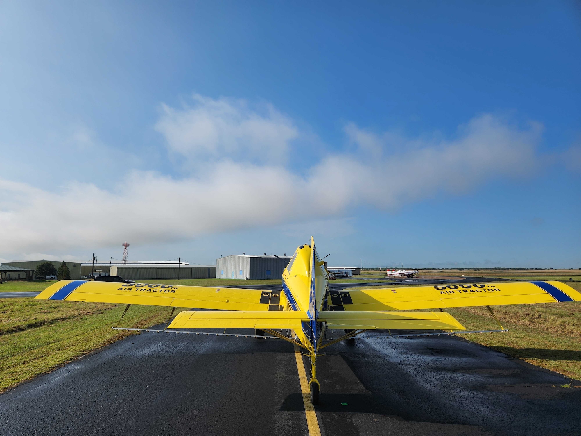 Air Tractor 500, a specialized agricultural aircraft, parked on the runway with a clear sky in the background. The plane is designed for efficient crop dusting and aerial application, showcasing its robust build and functional design.