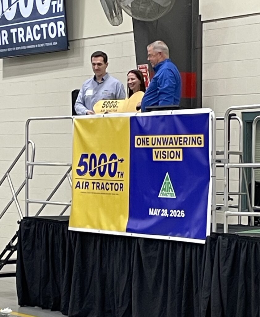Celebration of the 5000th Air Tractor aircraft milestone, featuring company representatives at the event. The banner highlights "5000th Air Tractor" and the date May 28, 2026, emphasizing Air Tractor's commitment to agricultural aviation innovation.